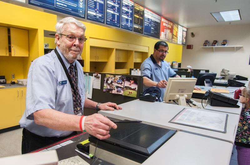 Postal Clerk at the counter 2 postal clerks working at a post office